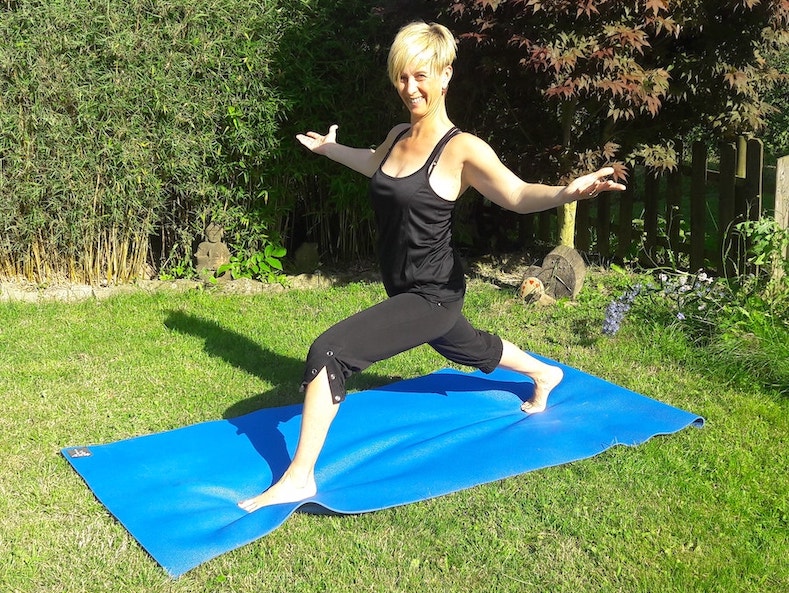 Frau macht Pilates auf blauer Matte im Garten - Mit freundlicher Genehmigung von Frau Troßmann